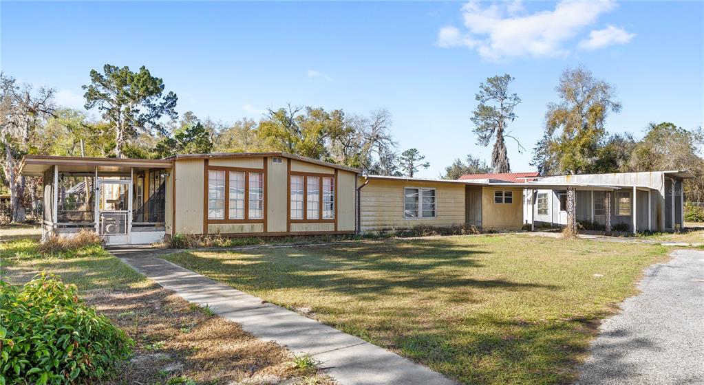 32443 Memory Lane Leesburg, FL 34788 - Photo 46 of 51 a front view of a house with a garden