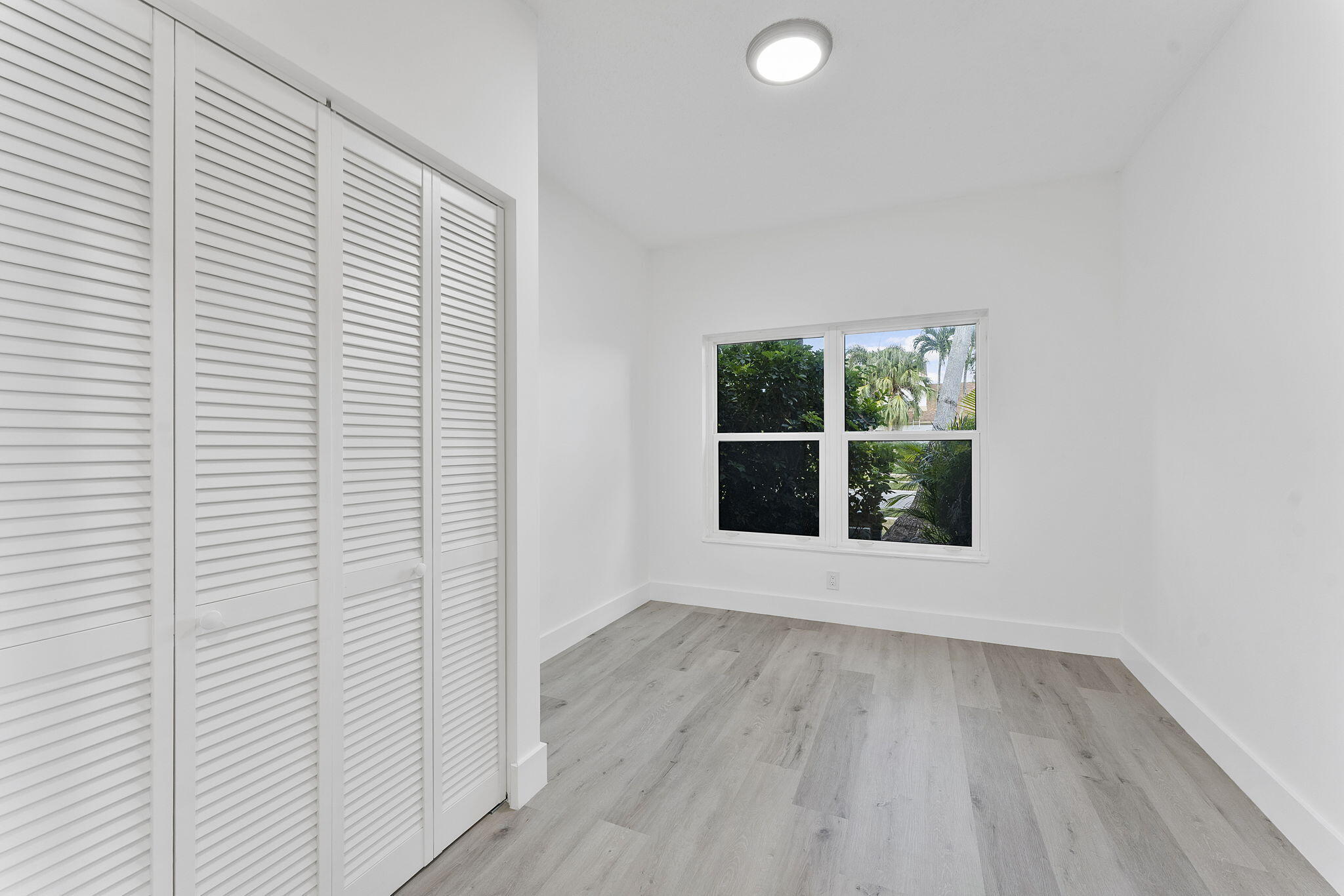 23157 Old Inlet Bridge Drive Boca Raton, FL 33433 - Photo 14 of 39 an empty room with wooden floor and windows