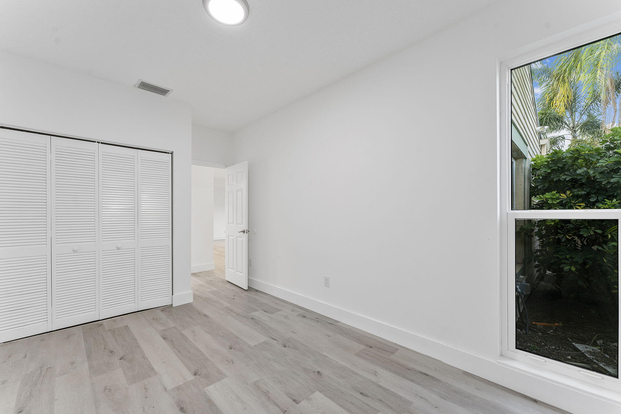 23157 Old Inlet Bridge Drive Boca Raton, FL 33433 - Photo 17 of 39 an empty room with wooden floor and windows