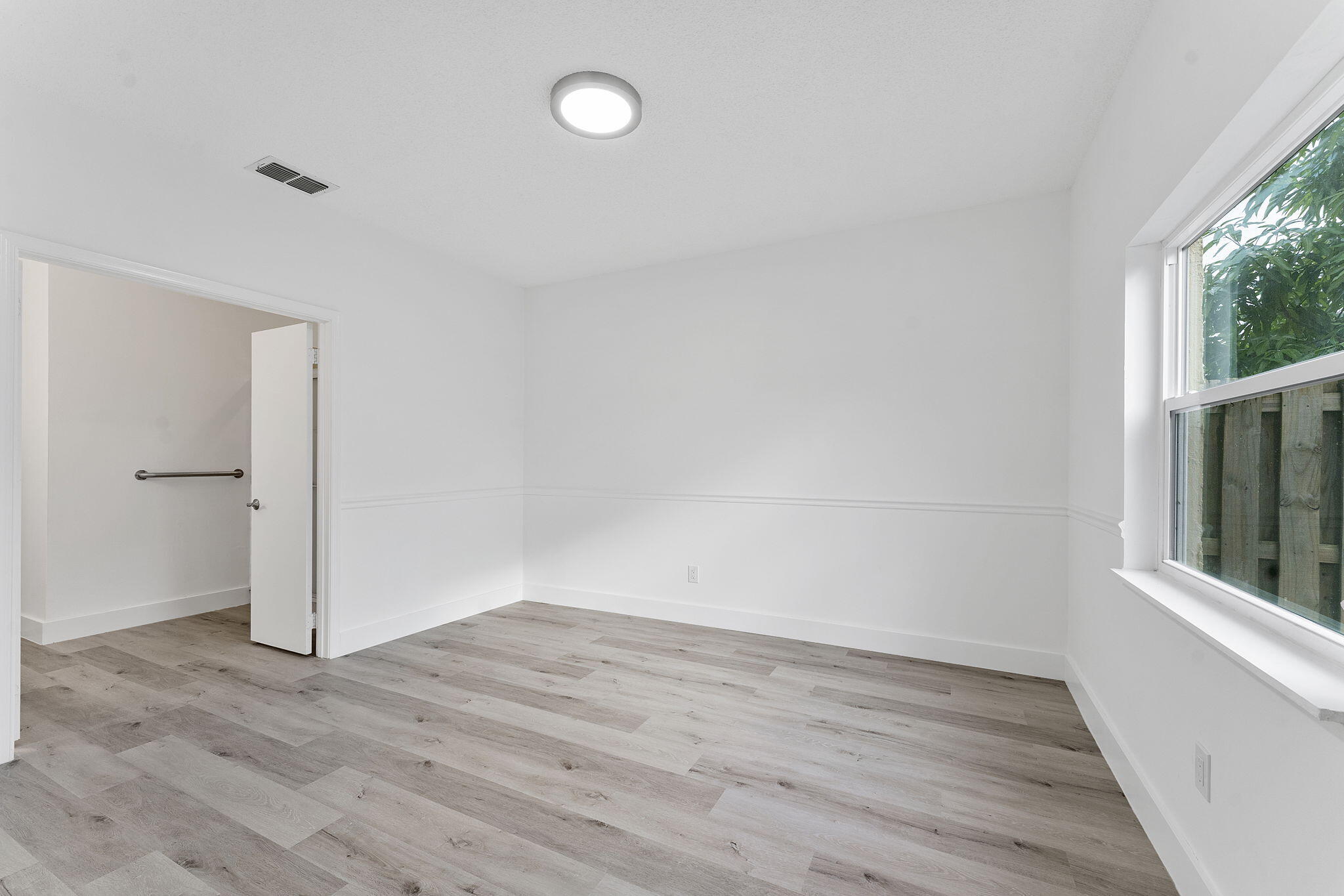 23157 Old Inlet Bridge Drive Boca Raton, FL 33433 - Photo 18 of 39 an empty room with wooden floor and windows