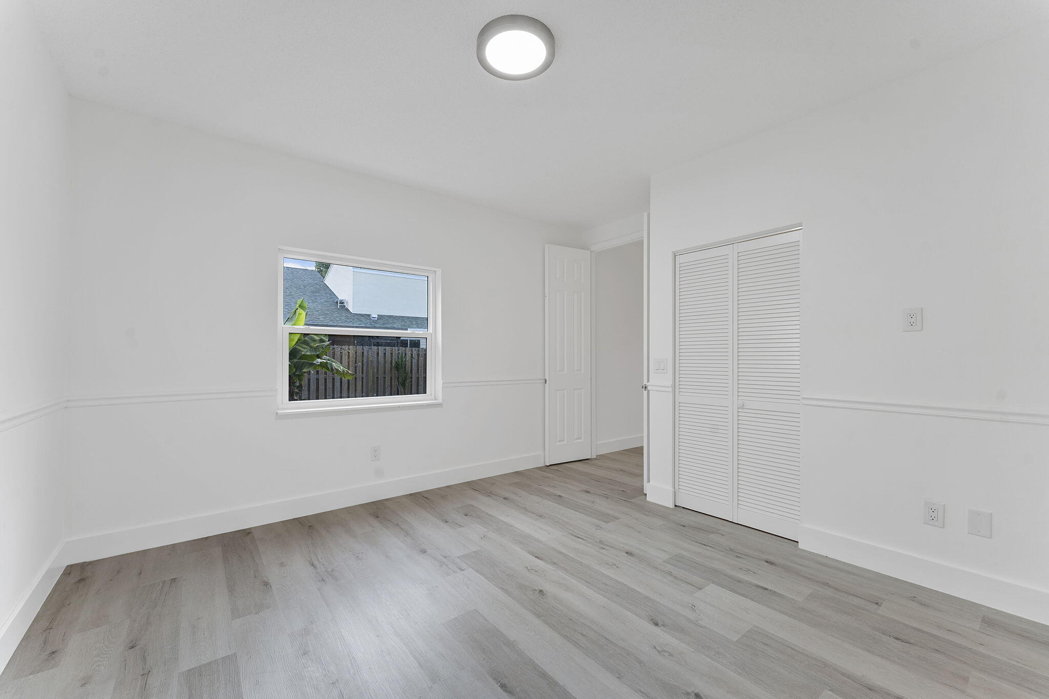 23157 Old Inlet Bridge Drive Boca Raton, FL 33433 - Photo 20 of 39 an empty room with wooden floor and windows
