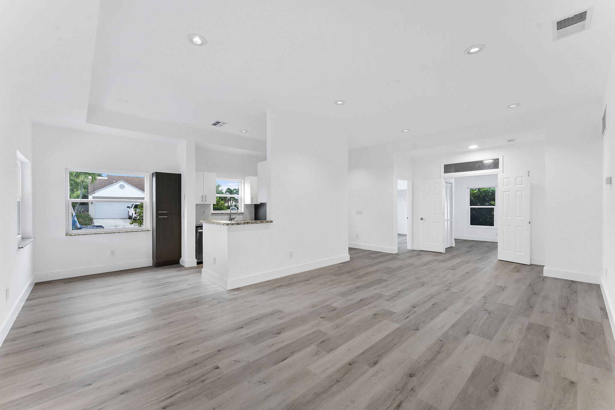 23157 Old Inlet Bridge Drive Boca Raton, FL 33433 - Photo 6 of 39 a view of a big room with wooden floor and a kitchen