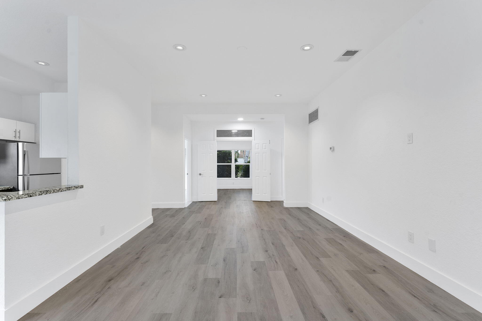 23157 Old Inlet Bridge Drive Boca Raton, FL 33433 - Photo 7 of 39 a view of an empty room with wooden floor and a window