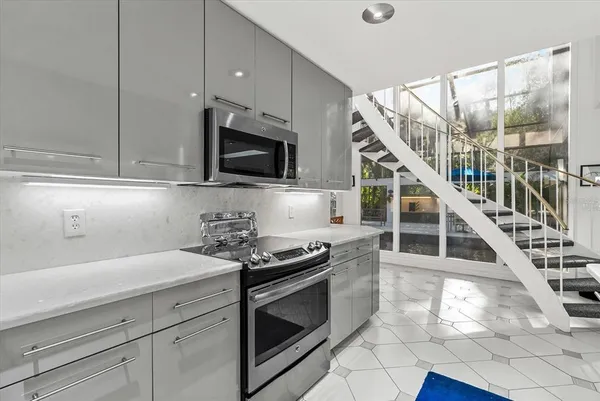 a kitchen with stainless steel appliances kitchen island granite countertop a refrigerator and a stove top oven