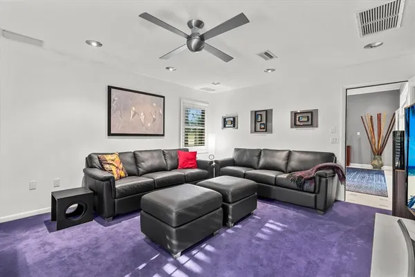 a spacious bedroom with a large bed a couch and a chandelier