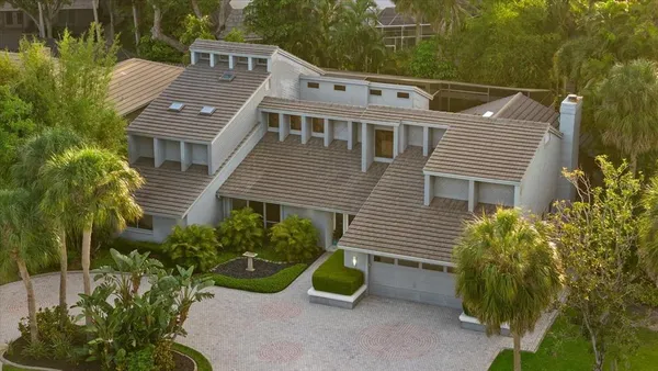 an aerial view of a house with a yard and a bench