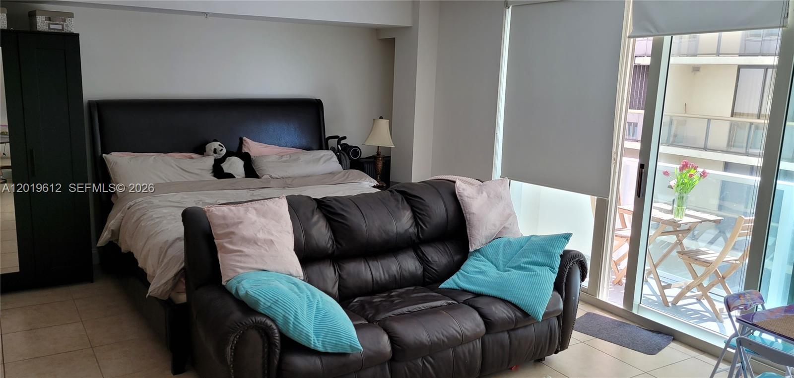 9499 Collins Avenue, Unit 705 Surfside, FL 33154 - Photo 11 of 29 a bed sitting in a bedroom next to a window