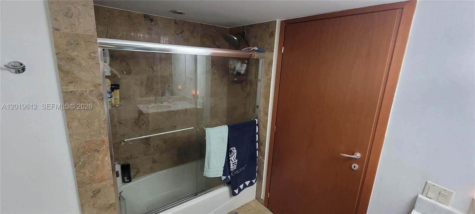 9499 Collins Avenue, Unit 705 Surfside, FL 33154 - Photo 12 of 29 a bathroom with a glass shower door