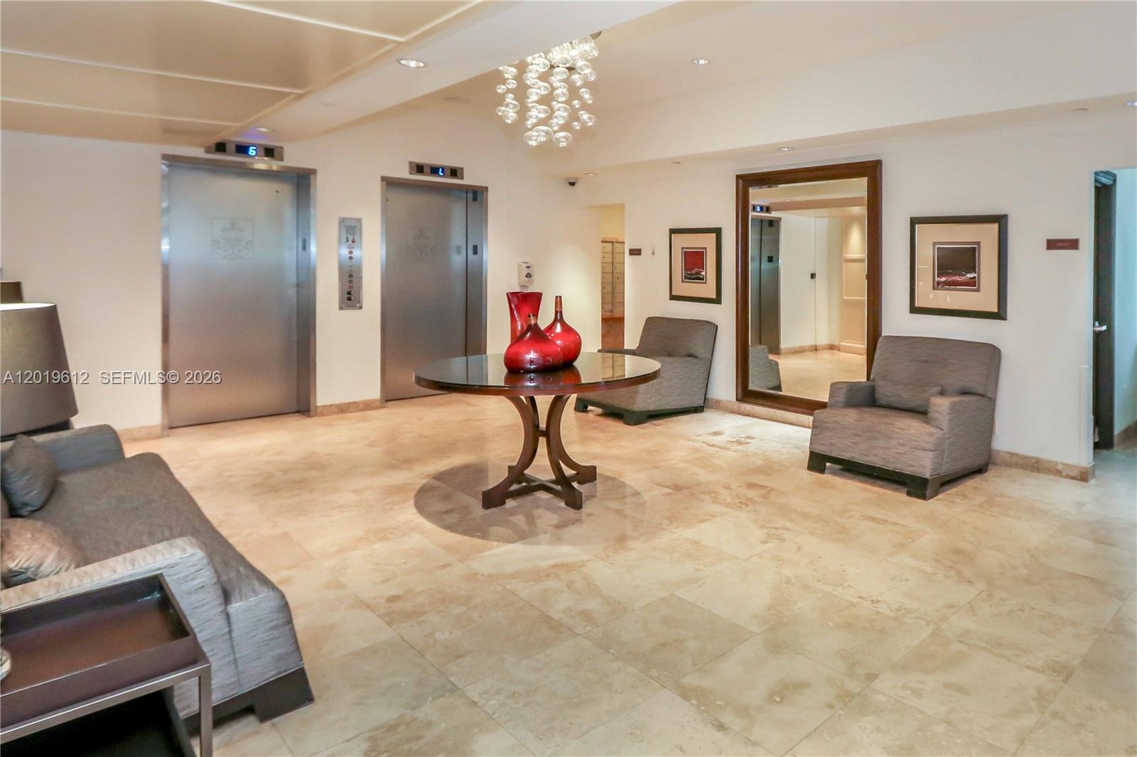 9499 Collins Avenue, Unit 705 Surfside, FL 33154 - Photo 18 of 29 a living room with furniture and a chandelier
