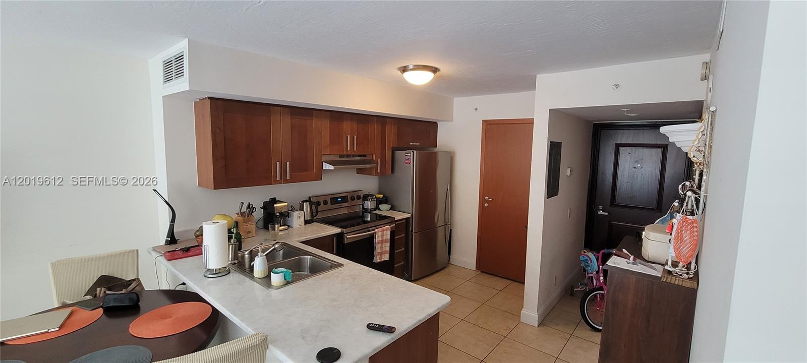 9499 Collins Avenue, Unit 705 Surfside, FL 33154 - Photo 5 of 29 a room with furniture a refrigerator and dresser