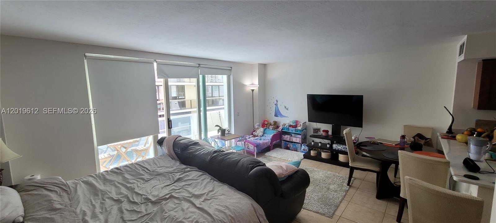 9499 Collins Avenue, Unit 705 Surfside, FL 33154 - Photo 10 of 29 a bedroom with a bed and a flat screen tv