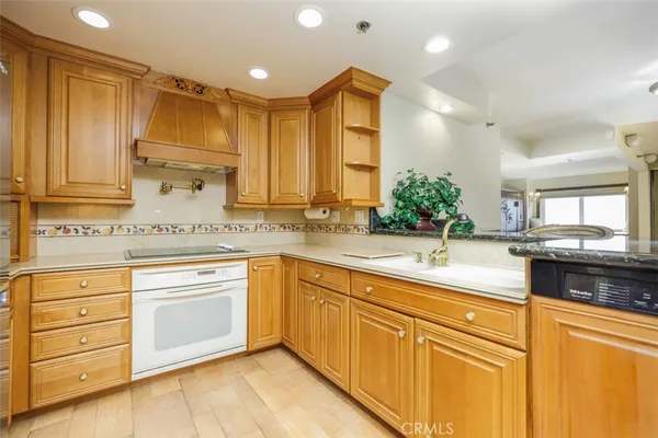 a kitchen with granite countertop a sink stainless steel appliances and cabinets
