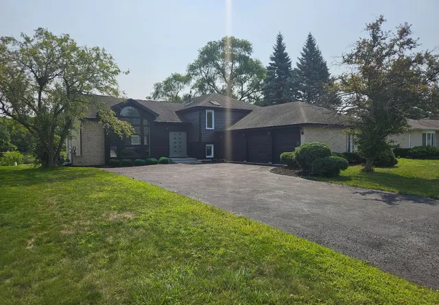 a front view of house with yard and trees