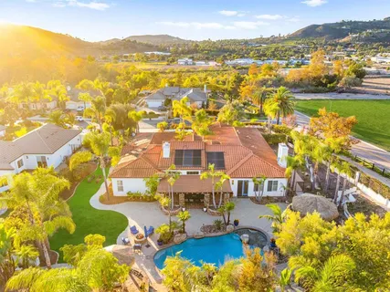 an aerial view of residential houses with outdoor space and trees