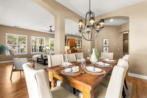 a bedroom with a large bed a chandelier and a window