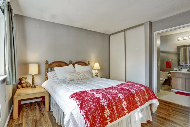 a bedroom with a bed and a mirror on dresser