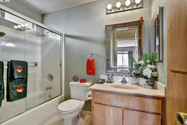 a bathroom with a sink vanity mirror and toilet