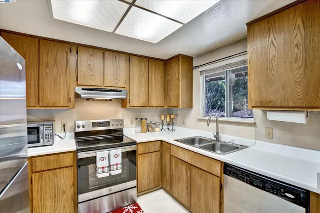 a kitchen with a sink stove top oven and cabinets