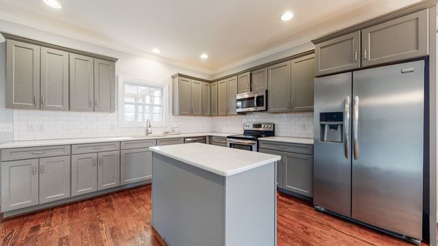 an empty room with wooden floor and ceiling fan