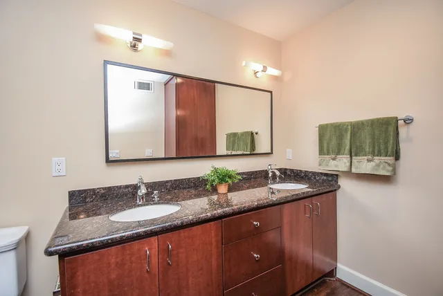 a bathroom with a granite countertop sink toilet and shower