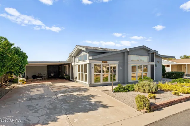 a front view of a house with a yard and potted plants