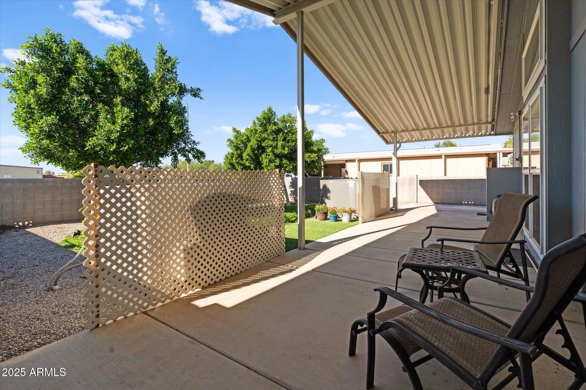 3700 South Tomahawk Road, Unit 26 & 27 Apache Junction, AZ 85119 - Photo 49 of 62 a view of a patio with table and chairs with wooden floor and fence