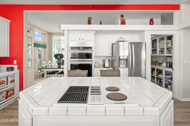 a kitchen with stainless steel appliances granite countertop a refrigerator and a stove top oven