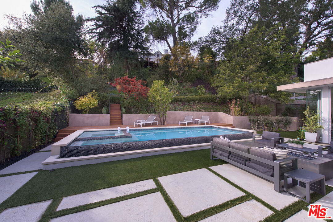 2213 Roscomare Road Los Angeles, CA 90077 - Photo 32 of 46 a view of a patio with couches table and chairs with potted plants and large trees