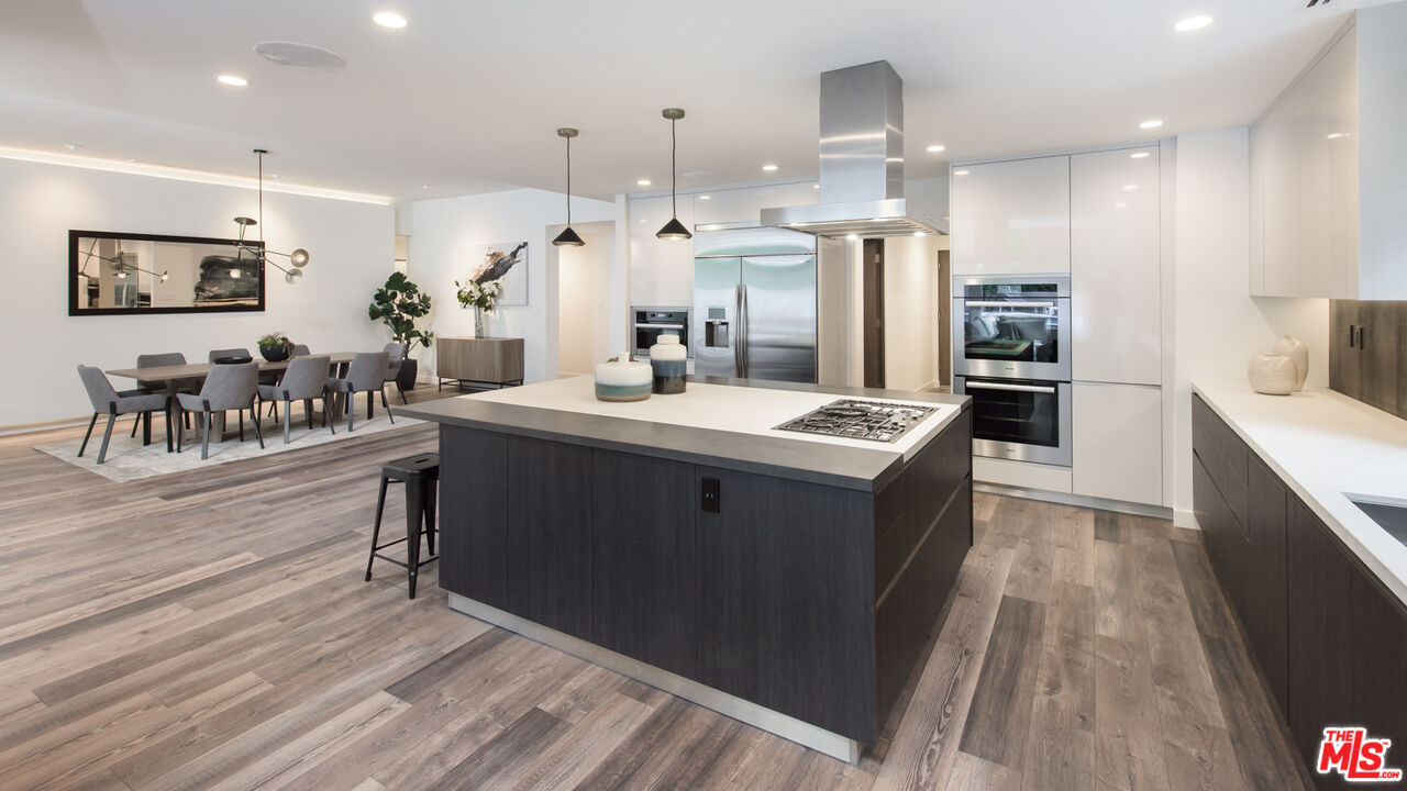 2213 Roscomare Road Los Angeles, CA 90077 - Photo 9 of 46 a kitchen with kitchen island a sink counter top space a stove and a refrigerator