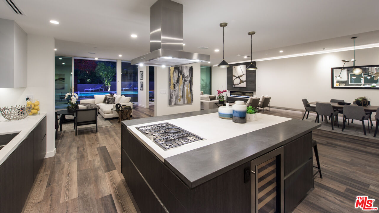 2213 Roscomare Road Los Angeles, CA 90077 - Photo 10 of 46 a kitchen with stainless steel appliances granite countertop a sink dishwasher and a dining table with wooden floor