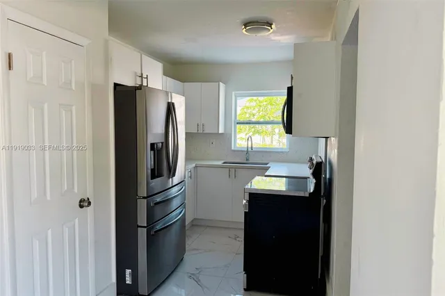 a kitchen with a refrigerator and a sink