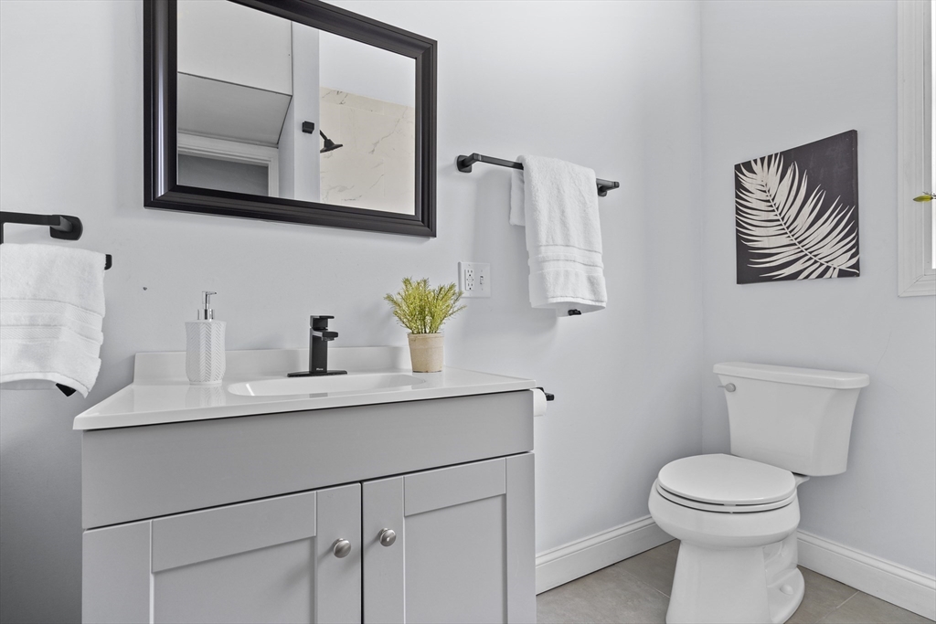 742 Bennington Street, Unit 3 Boston, MA 02128 - Photo 12 of 16 a bathroom with a toilet a sink and mirror