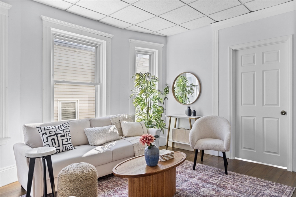 742 Bennington Street, Unit 3 Boston, MA 02128 - Photo 3 of 16 a living room with furniture a clock on wall and a window