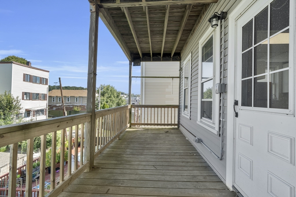 742 Bennington Street, Unit 3 Boston, MA 02128 - Photo 9 of 16 a view of a balcony with wooden floor and fence