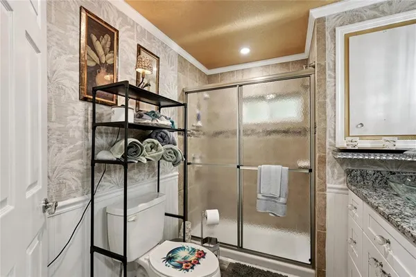 a bathroom with a granite countertop shower a mirror and a sink