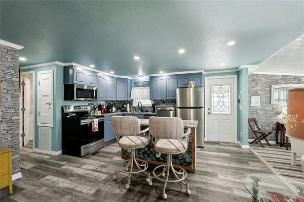 a kitchen with stainless steel appliances kitchen island granite countertop a refrigerator and a stove top oven