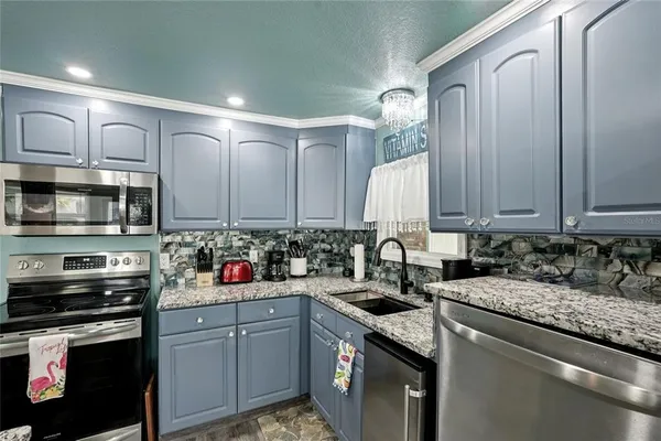 a kitchen with stainless steel appliances granite countertop a sink stove and cabinets
