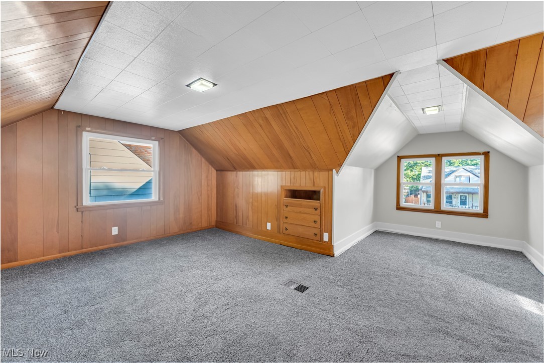 29034 Barjode Road Willowick, OH 44095 - Photo 16 of 24 Bonus room with vaulted ceiling, wooden walls, and light colored carpet