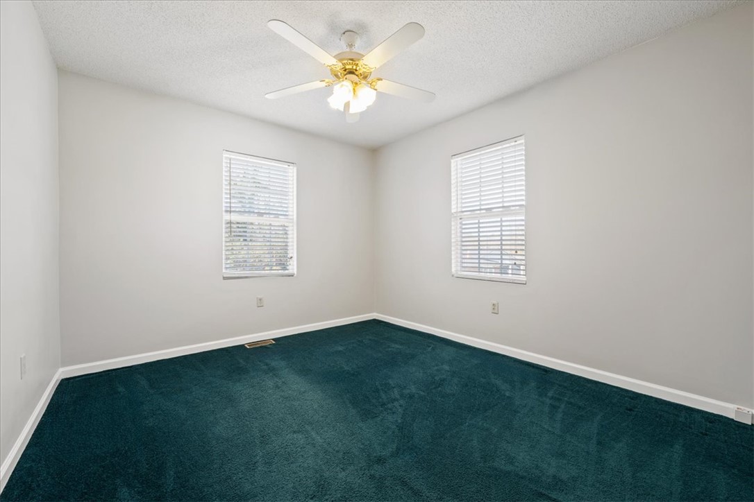 412 Carver Street Anderson, SC 29624 - Photo 13 of 23 This spacious bedroom offers ample natural light and a refreshing ceiling fan.