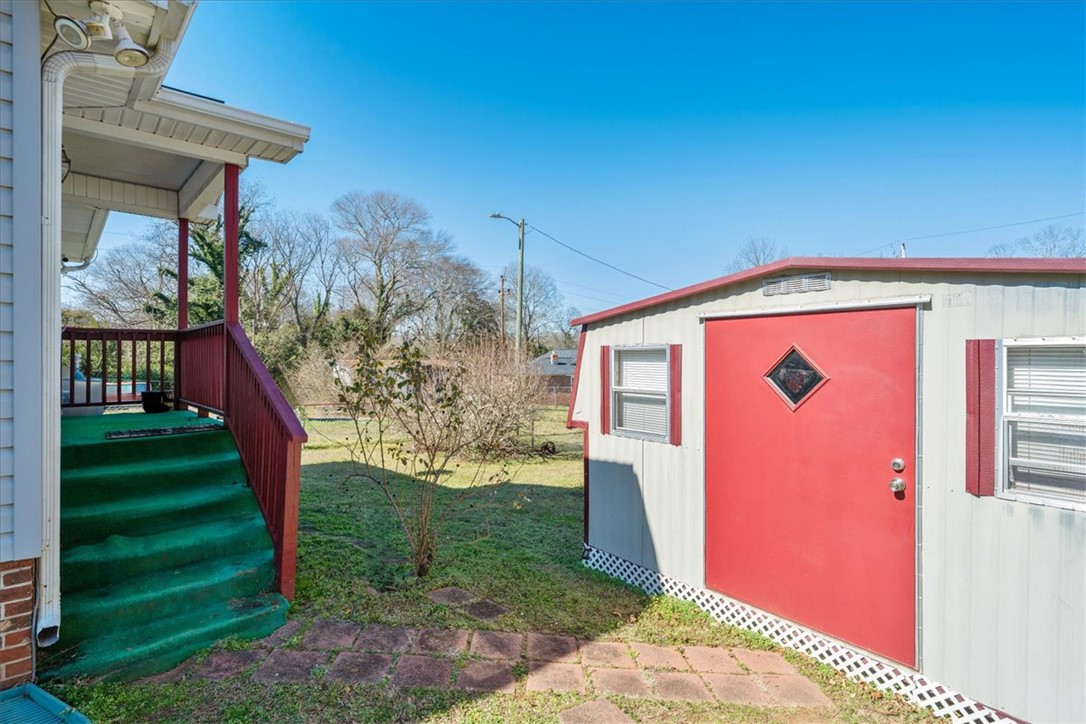 412 Carver Street Anderson, SC 29624 - Photo 20 of 23 This charming outdoor area features a quaint shed and a welcoming porch leading to the backyard.