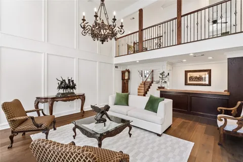 a large white kitchen with a large counter space a stove and a chandelier