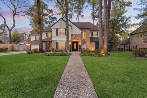 a front view of a house with a yard and potted plants