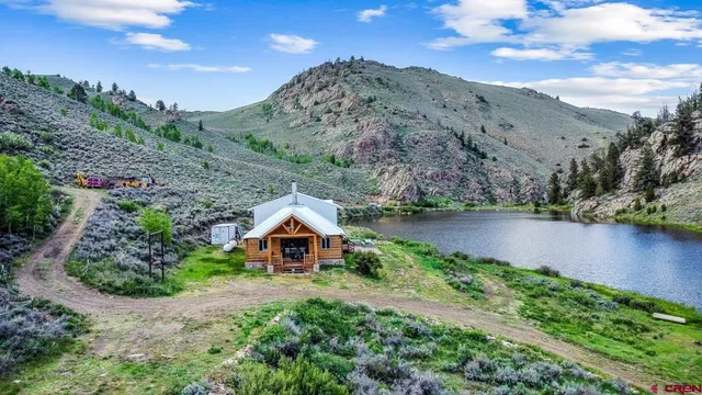a backyard of a house with lots of green space and lake view