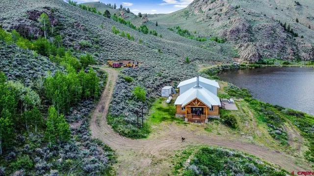 an aerial view of a house with a yard and lake view