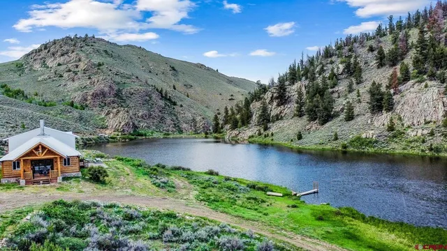an aerial view of a house with a yard and lake view