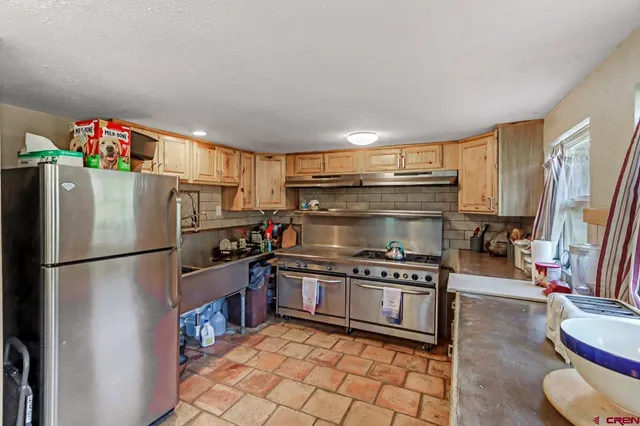 a kitchen with granite countertop a refrigerator and a stove
