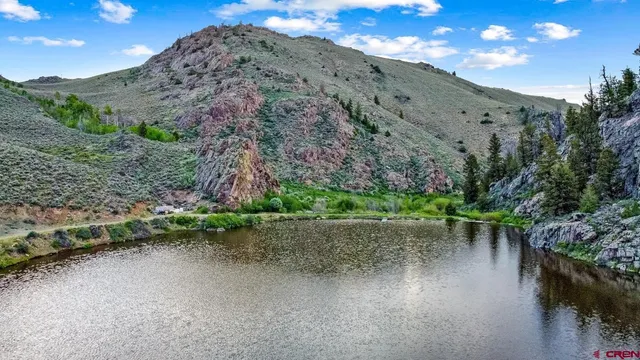 a view of a wooden bridge with large trees