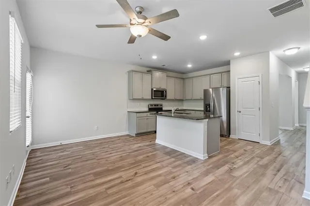 a kitchen with stainless steel appliances granite countertop a refrigerator and a sink