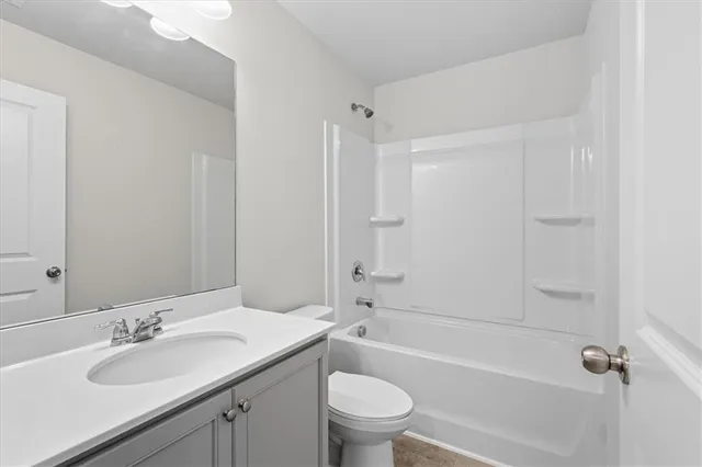 a bathroom with a granite countertop sink a toilet and shower
