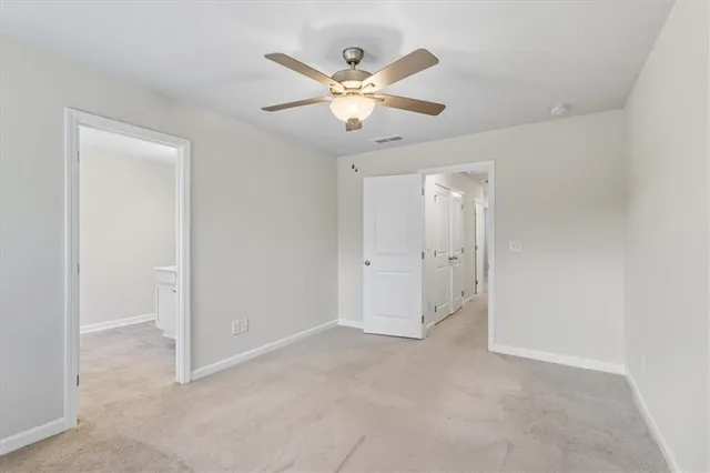 a view of an empty room with a ceiling fan